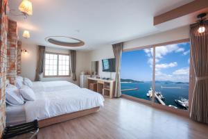 统营市统营湾公寓酒店度假村的一间卧室设有一张大床和一个大窗户