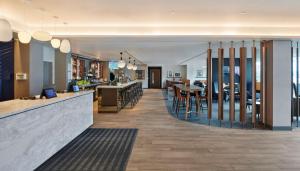 希灵登Hyatt Place London Heathrow Airport的餐厅设有酒吧,配有桌椅