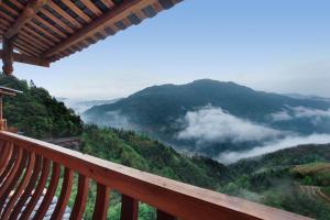 龙胜Baike Boutique Hotel的从带云的山景阳台上欣赏风景