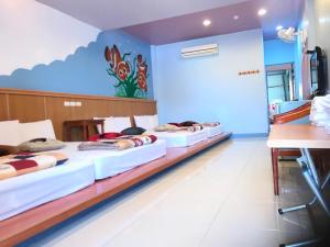 南湾南湾KiKi民宿的一间设有四张床的房间,墙上挂着壁画