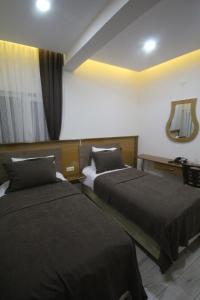 ZaraGulistan Hotel的酒店客房,设有两张床和镜子