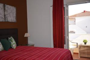 罗萨里奥港Apartamento Playa Blanca Holiday的一间卧室设有红色的床和窗户。