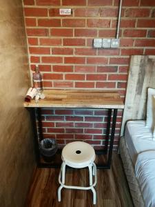 瓜拉丁加奴莱斯宾馆的砖墙旁的小桌子和凳子
