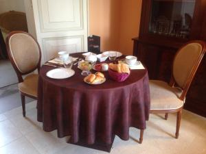 索姆河畔的圣瓦列里罗马尔城堡旅馆 - 百德索姆河德的一张桌子,上面有紫色的桌布和面包