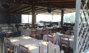 罗通多港Ladumar Sardinia的一间设有白色桌椅的用餐室