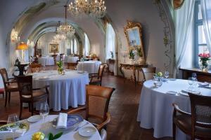 瓜热讷格雷内酒店的餐厅设有白色的桌椅和吊灯。