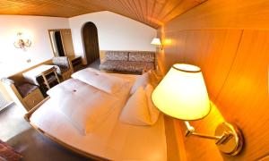 思科纳奥博塔波霍弗酒店的一间卧室配有一张带灯和沙发的床