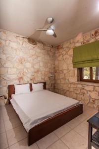 希维利Luxurious Stone House的一间卧室设有一张床和石墙
