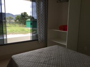 戈亚斯州上帕莱索Mirante do Morro的一间卧室设有一张床和一个美景窗户。