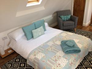 韦茅斯Pump View的一间卧室配有一张带椅子和枕头的床