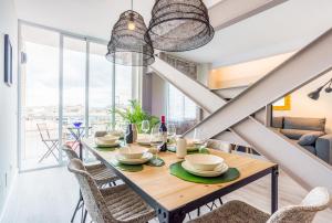马拉加MalagaSuite Premium Deluxe Alameda的一间带桌椅和大窗户的用餐室