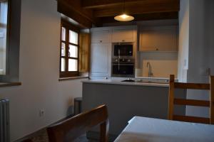 奥尼斯Corte del Rondiellu 2的厨房配有白色家电和桌椅