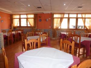 加鲁查Hostal Cortés的用餐室设有桌椅和窗户。