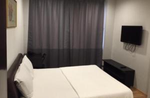 新加坡Hotel Conforto的卧室配有白色的床和电视。