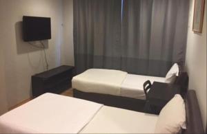 新加坡Hotel Conforto的小房间设有两张床和电视