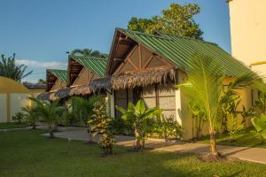莱蒂西亚亚马逊住宿加早餐酒店的一座带绿色屋顶和一些树木的房子