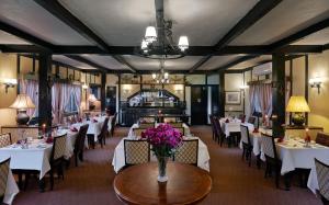 Ringlet金马仑湖高地湖畔小屋度假村的餐厅配有白色的桌椅和鲜花