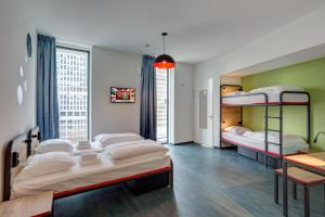 阿姆斯特丹阿姆斯特丹阿姆斯特尔梅宁阁酒店的一间卧室配有三张双层床和一张桌子