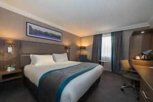 诺丁汉假日诺丁汉酒店的配有一张床和一张书桌的酒店客房
