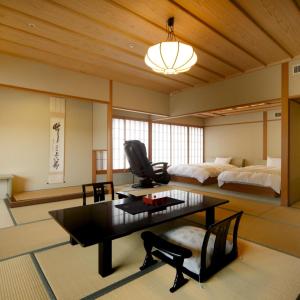 琴平町琴平温泉度假酒店的客厅配有桌子和床。