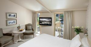 海法Templers House Boutique hotel的一间卧室配有一张床,并在一间客房内配有电视。