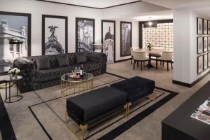 马德里卡斯蒂利亚美利亚酒店的客厅配有沙发和桌子