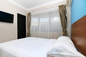 瑟古邦瑟古邦巴淡岛萨芬娜旅馆的卧室配有白色的床和窗户。