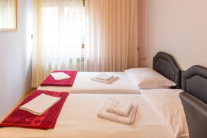 布德瓦Guesthouse Blue Coast的两张位于酒店客房的床,配有毛巾