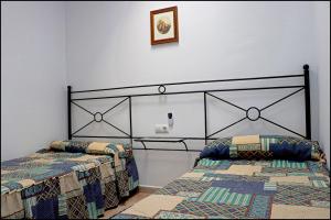 科尼尔-德拉弗龙特拉Apartamento Sol II的卧室配有两张床,墙上挂着一幅画