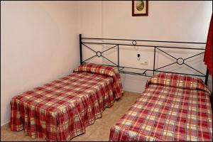 科尼尔-德拉弗龙特拉Apartamento Sol II的一间卧室配有两张床和一张铺着地毯的毯子。
