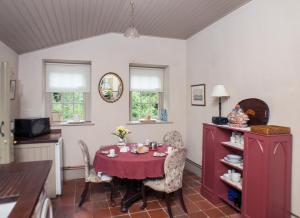 莱克斯利普Batty Langley Lodge的一间用餐室,配有红色的桌子和椅子