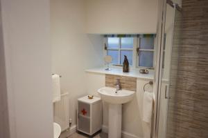 彭赞斯The Old Workshop - Drift的白色的浴室设有水槽和淋浴。