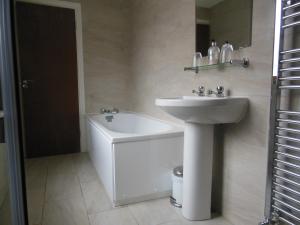 Winterborne KingstonGreyhound Inn的白色的浴室设有水槽和浴缸。