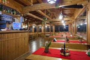 Medven西尼亚维尔生态酒店的一间设有一排桌子的餐厅和一间酒吧