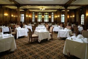 阿尼克传统白天鹅酒店的一间设有白色桌椅的用餐室
