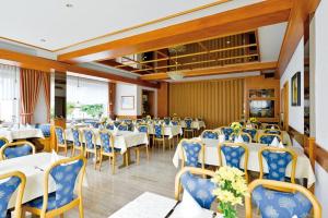 罗滕堡罗瑟尔酒店的宴会厅配有白色的桌子和蓝色的椅子