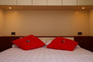 圣雷莫Gaudio 22 Apartment的床上有2个红色枕头