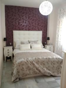 塞维利亚TWO BEDROOMS Leonor Dávalos的一间卧室设有一张红色墙壁的大床