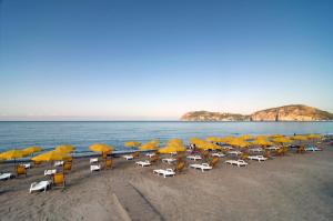 卡梅罗塔码头维拉吉奥奥迪西露营酒店的沙滩上的一把椅子和遮阳伞