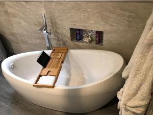 PentraethLon y Traeth Bed & Breakfast的带浴缸的浴室和木板