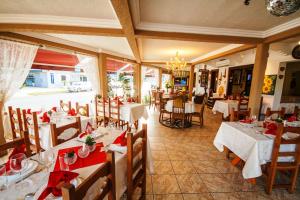 瓜拉图巴Hotel Cabana Suiça的餐厅配有白色的桌椅和红色的餐巾