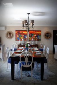卡图Kathuhari Guesthouse的一间带桌子和白色椅子的用餐室