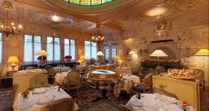 巴黎贝德福酒店的餐厅设有白色的桌椅和天花板