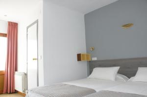 帕拉弗鲁赫尔Hostal Plaja i Pati de Can Plaja的一间卧室设有两张白色的床和窗户