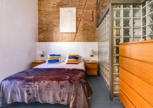 略夫雷加特河畔奥斯皮塔莱特Camp Nou Apartment的一间卧室设有一张床和砖墙