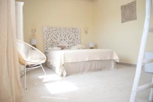 加利波利Villa dei Ginepri的白色卧室配有床和椅子