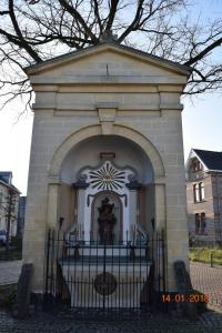 法尔肯堡Aan 't kapelke的一座建筑,里面有一个门,上面有雕像