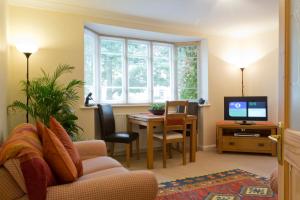 约克波普勒服务式公寓酒店的客厅配有沙发和带电视的桌子