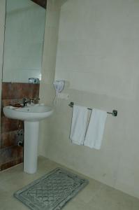 Sidi BennourSania Hotel的浴室配有盥洗盆、镜子和毛巾