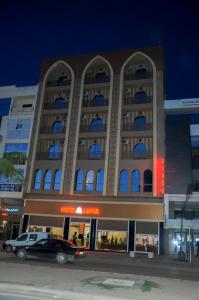 Sidi BennourSania Hotel的前面有停车位的建筑